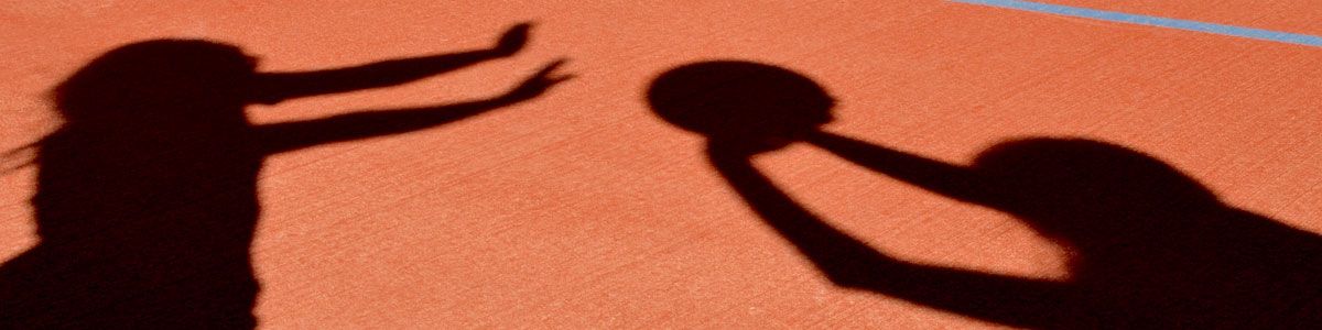 Shadows of 2 girls playing netball outdoors